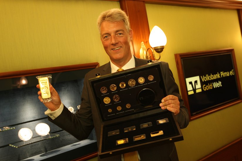 Hauke Haensel  mit einem Musterkoffer und einem Goldbarren  im neuen Gold-Shop. Fotos: Förster