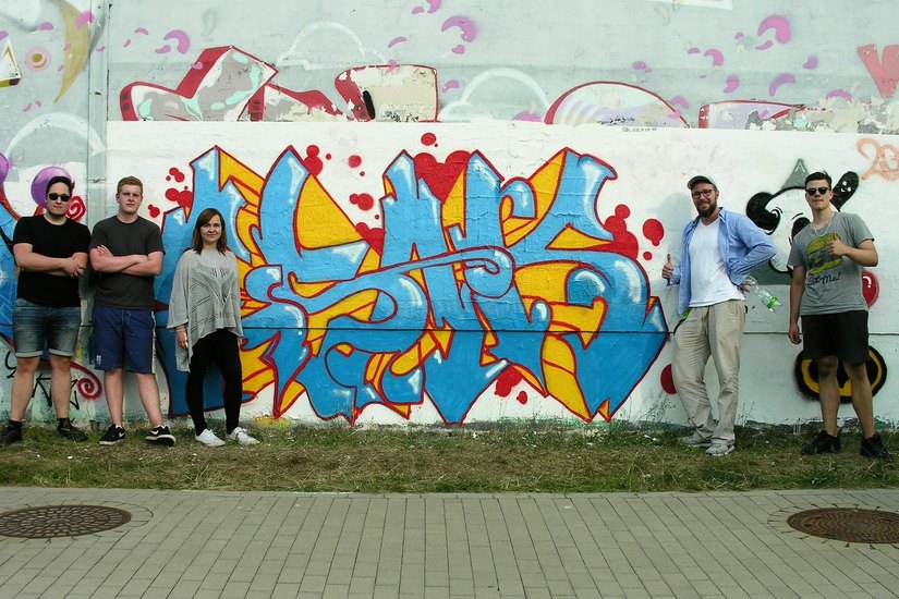 Florian, Nick, Mandi, Sebastian und Dennis (v.l.n.r.) trotzten der Hitze und sprayten über mehrere Stunden neues Graffiti an die alte Turnhallenwand in der Juri-Gagarin-Straße. Foto: Soziales Netzwerk