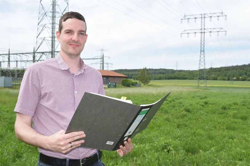 Der Bürgermeister Achim Wünsche steht genau dort, wo der Investor einen Solarpark errichten möchte - in unmittelbarer Nähe zum Umspannwerk und entlang der Bahnstrecke.
