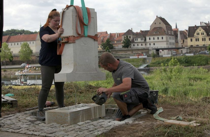 Steinbildhauerin Maria Kaiser (li) stellt zusammen mit Sven Mudlagk (re) von der Firma Naturstein Naumann GmbH aus Ottendorf-Okrilla eine historische Nachbildung der Viertelmeilensäule in Pirna-Copitz auf.