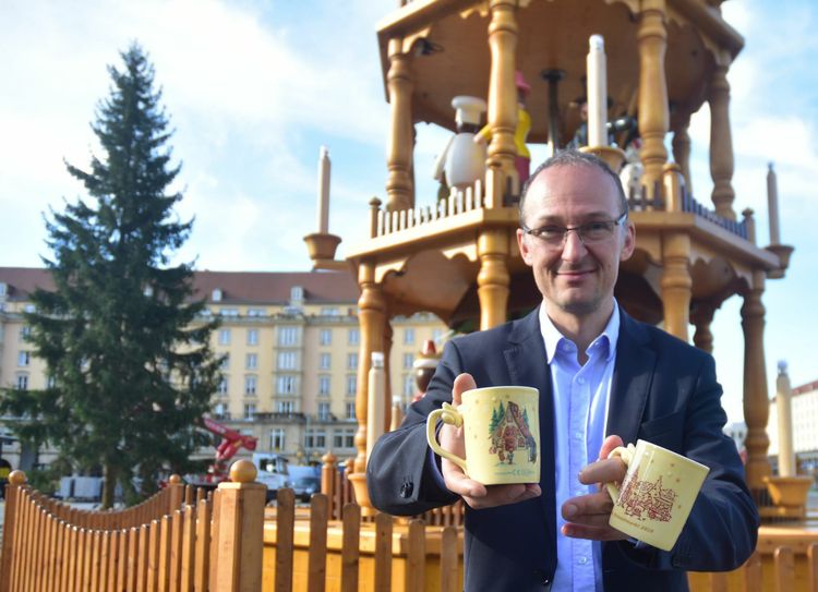 Amtsleiter Dr. Robert Franke präsentiert die aktuelle Striezelmarkt-Tasse.