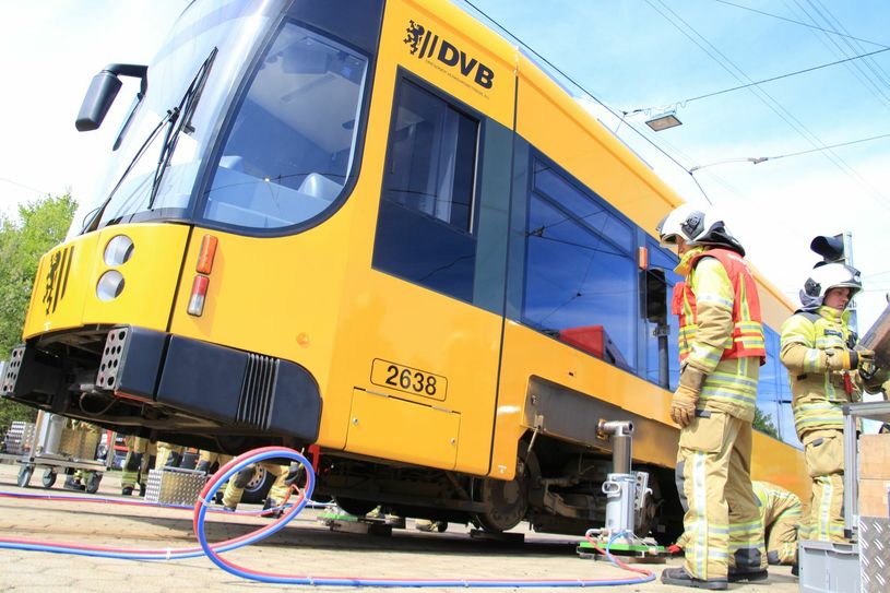 Kameraden der Dresdner Feuerwehr demonstrieren, wie die Bahn mittels Verschiebezylinder angehoben werden kann. Im realen Einsatz sind die Bedingungen ringsum meistens schwieriger.