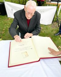 Rolf Ebert schreibt sich in das Goldene Buch der Stadt Lübben ein.
