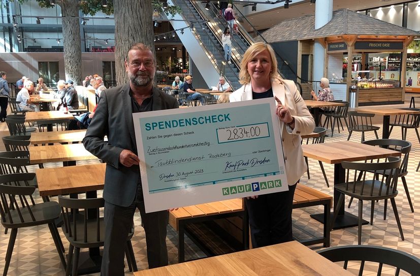 Antje Arnold (re.) vom Kaufpark Nickern bei der Spenden-Übergabe an Gerold Augart vom Taubblindendienst.