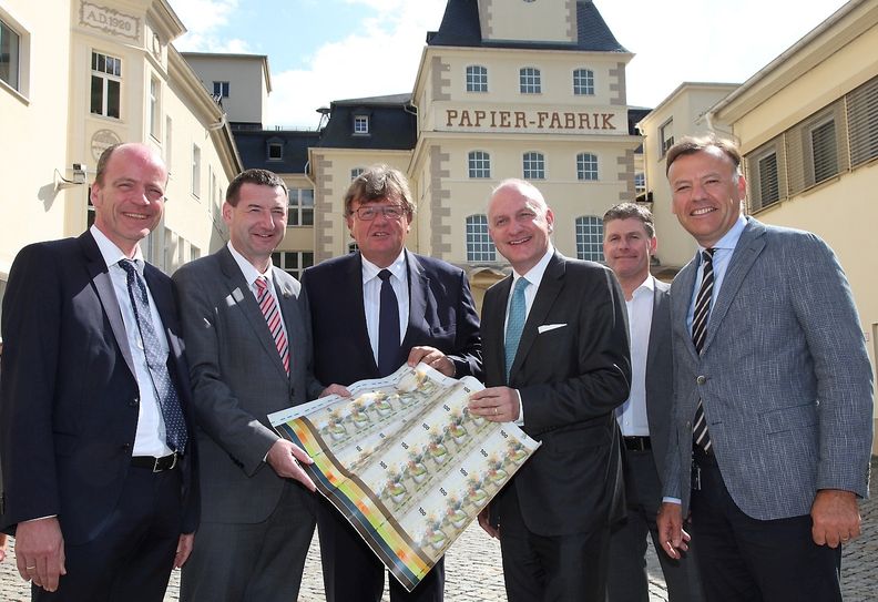 V.l.: Sachsens Finanzminister Dr. Matthias Haß, Wahlkreisabgeordneter Jens Michel, Dr. Johannes Beermann (Vorstandsmitglied der Deutschen Bundesbank), Dr. Wolfram Seidemann, Vorsitzender der Geschäftsführung G+D Curreny Technology), Werksleiter René Steiger und Celems Berger (Vorsitzender der Geschäftsführung Louisenthal) mit einer sogenannten Testbanknote. Foto: D. Förster