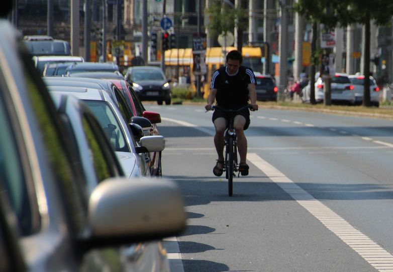 Gefährliche Kombination: parkende Autos, Radweg, Straße. Öffnet jetzt ein Autofahrer seine Autotür, wird der Radfahrer direkt in den fließenden Verkehr abgedrängt.