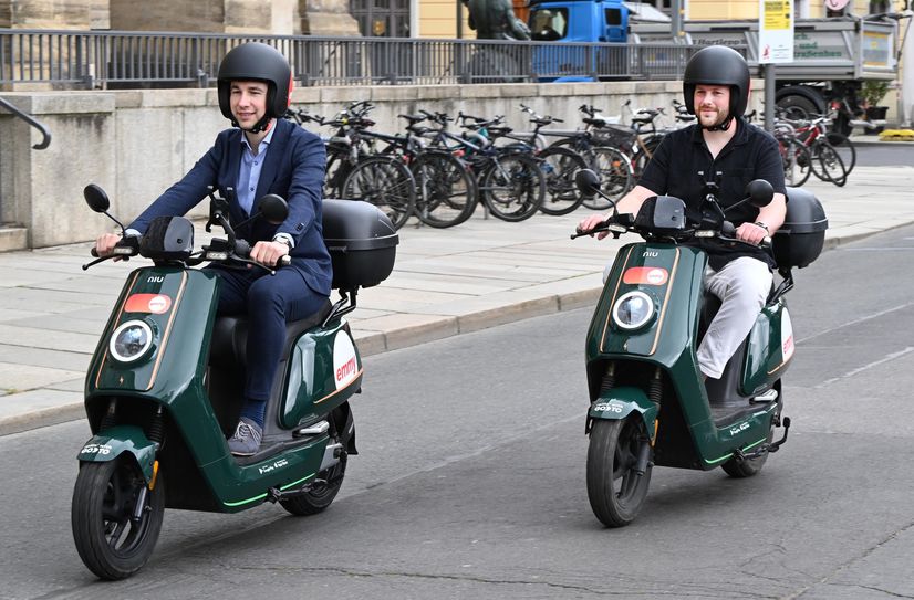 Verkehrsbürgermeister Stephan Kühn und »emmy« General Manager Christopher Schech führen die neuen E-Roller vor.