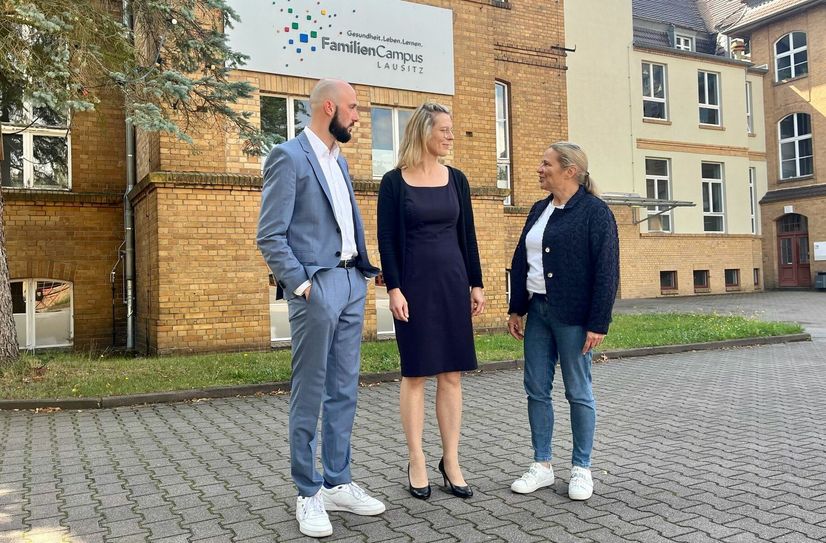 Tom Lehnert, Geschäftsführer der Rettungsdienst Niederlausitz gGmbH, und Grit Klug (re.), Beigeordnete des Landkreises Oberspreewald-Lausitz, begrüßen Nicole Kockrick am FamilienCampus Lausitz.
