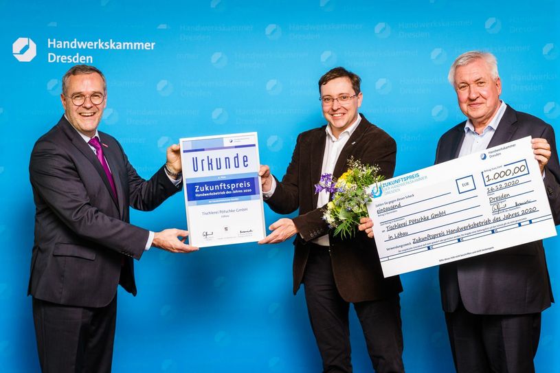 Jörg Dittrich, Präsident der Handwerkskammer Dresden, übergibt die Urkunde an Thomas und Wilfried Pötschke. Foto: Handwerkskammer Dresden/André Wirsig