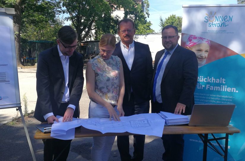 Vor den Bauplanen: Kai Hölzig (Baukonzept Planungsgesellschaft), Dr. Silke Nolte-Buchholtz (Leiterin Kinder-Palliativ-Zentrum), Prof. Dr. Michael Albrecht (medizinischer Vorstand der Universitätsklinik) und Andreas Führlich (Vorstandsvorsitzender des Sonnenstrahl e.V.).