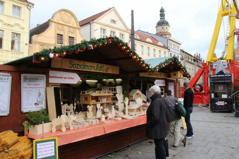 Der Stand des Lebensweg e.V. befindet sich noch bis 23. Dezember direkt neben dem Riesenrad auf dem Altmarkt. Foto: jho