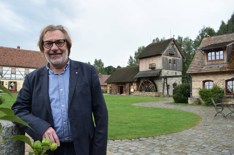 Der Vorsitzende des Krabat e.V., Reiner Deutschmann, steht auf dem wohl bekanntesten Areal in der Krabat-Region, der Krabat-Mühle in Schwarzkollm.