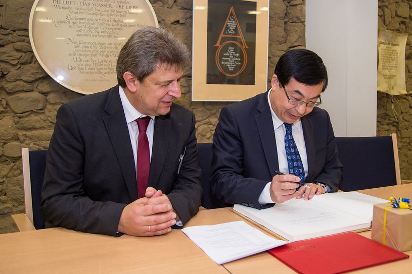 Gästebuch: Der Gesandte-Botschaftsrat Weidong Wang (rechts) beim Eintrag ins Gästebuch der Stadt. Fotoquelle: RocciPix