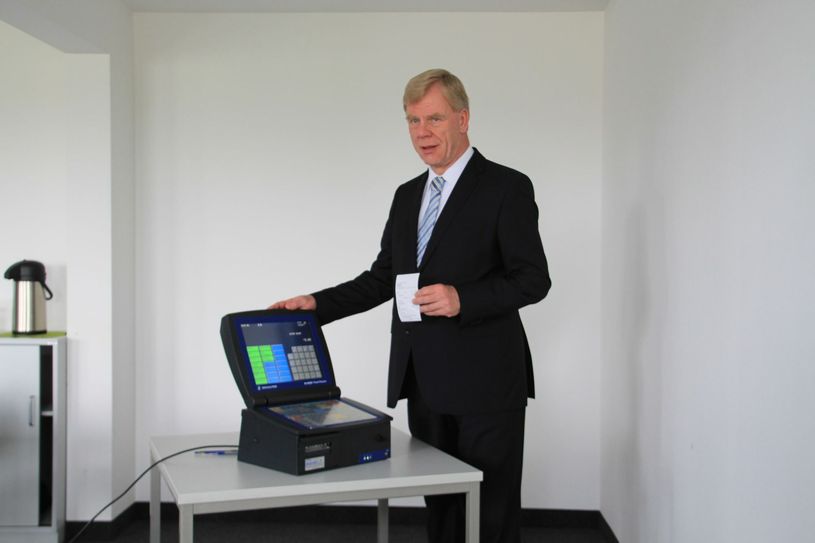 Finanzminister Georg Unland an einer gebräuchlichen Registrierkasse. Über eine „spezielle Handhabung“ ist es möglich, dass Umsätze gar nicht mehr auftauchen. Dem will Unland einen Riegel vorschieben.