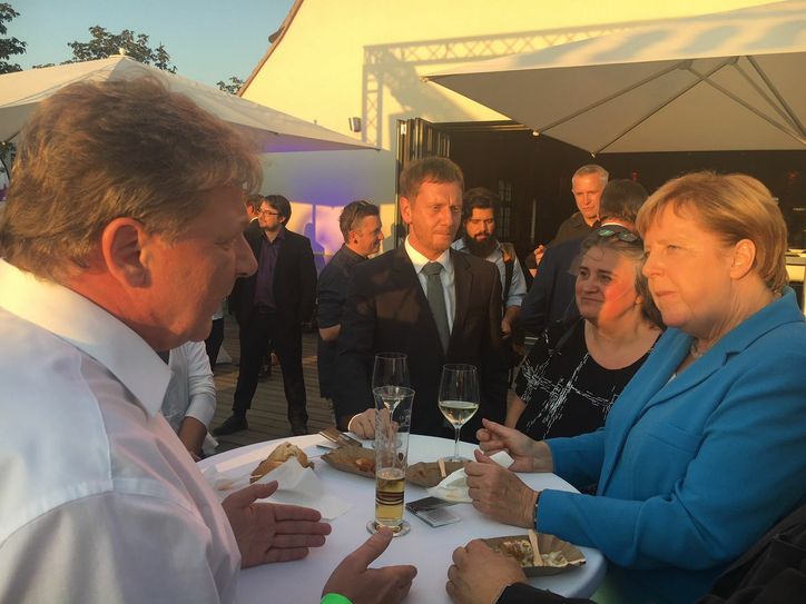 Verlagsleiter Torsten Berge (l.) im Gespräch mit Bundeskanzlerin Angela Merkel (r.) und Ministerpräsident Michael Kretschmer (m.). Foto: Hirche