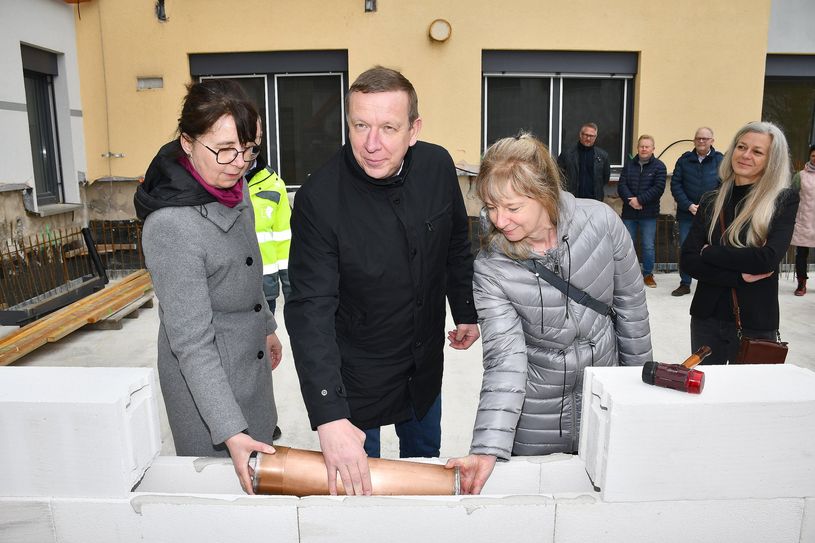 Bildungsdezernentin Anja Miersch, Landrat Christian Jaschinski und die Abteilungsleiterin am OSZ für Metall- und Kfz-Technik, Katharina Trautmann-Blasius (v.l.n.r.), versenkten die Zeitkapsel im Grundstein des Anbaus am Oberstufenzentrum in Elsterwerda.