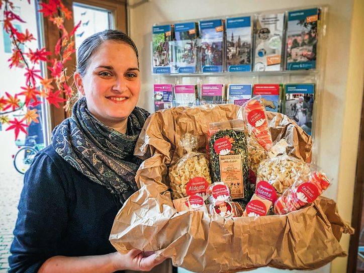 Sara Händler vom TouristService Pirna mit einem ganzen Korb voll Köstlichkeiten aus der Sächsischen Schweiz, die nun in den TouristInfos neben Wanderkarten oder Postkarten verkauft werden. (blog.saechsische-schweiz.de) Foto: TVSSW