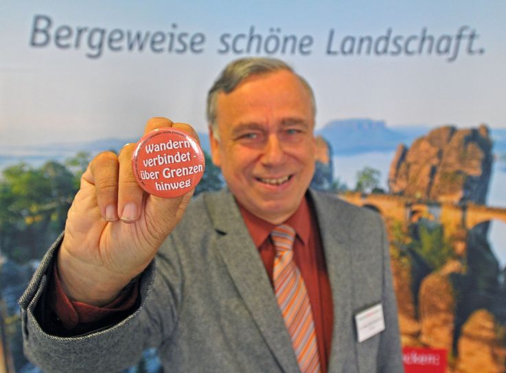 Dr. Hans-Ulrich Rauchfuß, Präsident des Deutschen Wanderverbandes (DWV) mit dem Button „Wandern verbindet – über Grenzen hinweg“, den der Verband während des Wandertages in Sebnitz an die Wandertagsbesucher verteilt. Der  DWV tritt seit seiner Gründung vor über 130 Jahren für gegenseitige Achtung und Respekt ein. Foto: J. Kuhr / Deutscher Wanderverband