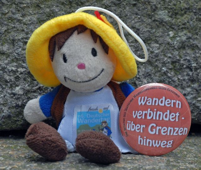 Wandertagsmaskottchen „Lotte“ zusammen dem Buton des Deutschen Wanderverbandes „Wandern verbindet – über Grenzen hinweg“, den der Verband während des Wandertages in Sebnitz an die Wandertagsbesucher verteilt. Foto: J. Kuhr / Deutscher Wanderverband