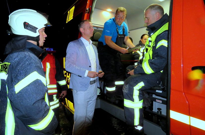 Der Stolpener Bürgermeister Maik Hirdina (2. v. li.) macht sich bei der Einsatzleitung ein Bild von der Lage.