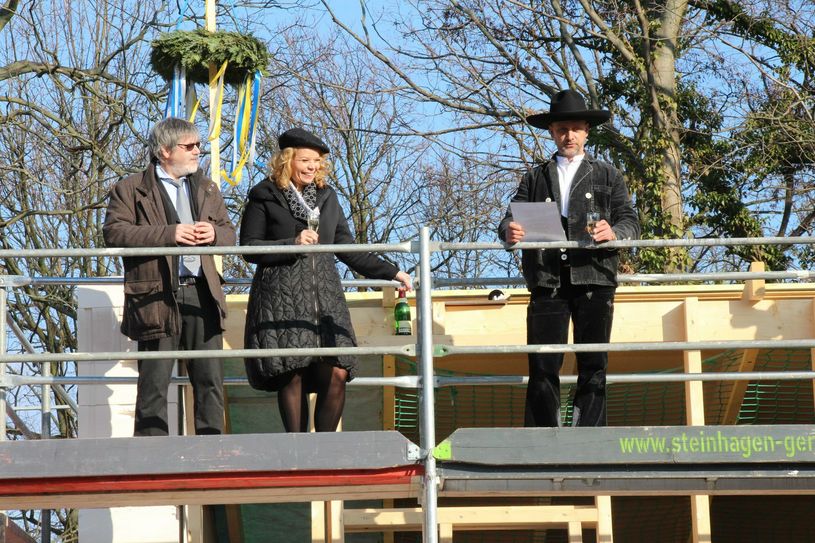 Pia Reisert (Mitte) und Michael Blümchen (li.), Geschäftsführung im Bereich Altenhilfe im Unternehmensverbund Evangelischen Diakonissenhaus Berlin Teltow Lehnin, lauschen den Richtspruch von Zimmerergeselle Sandro Beck (re.) von der Kero Zimmerei und Holzbau GmbH aus Rothenburg (Oberlausitz). Foto: sts