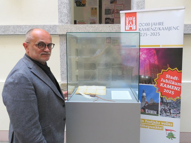 Der Kamenzer Oberbürgermeister Roland Dantz vor dem Faksimile der Urkunde, welche als erster schriftlicher Beleg für die Existenz von Kamenz gilt. Sie stammt aus dem Jahr 1225.Foto: Matthias Stark