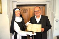 Die Äbtissin des Klosters St. Marienstern, Sr. Gabriela Hesse und Oberbürgermeister Roland Dantz mit der Urkunde des Bischofs Bruno II., der ersten urkundlichen Erwähnung der Stadt Kamenz aus dem Jahr 1225. Foto: Stadtverwaltung Kamenz