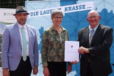 Ministerin Kathrin Schneider überreicht den Förderbescheid an Bürgermeister Hans-Jürgen Dreger (r.) und Amtsdirektor Tobias Hentschel.