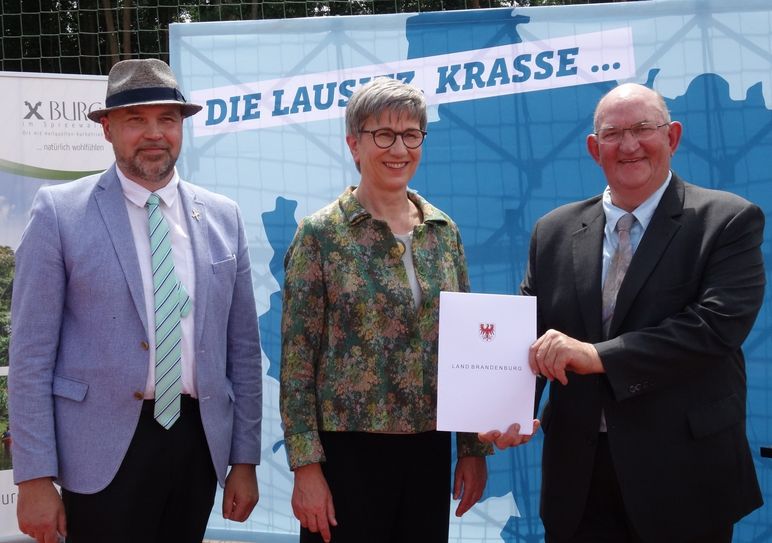 Ministerin Kathrin Schneider überreicht den Förderbescheid an Bürgermeister Hans-Jürgen Dreger (r.) und Amtsdirektor Tobias Hentschel.