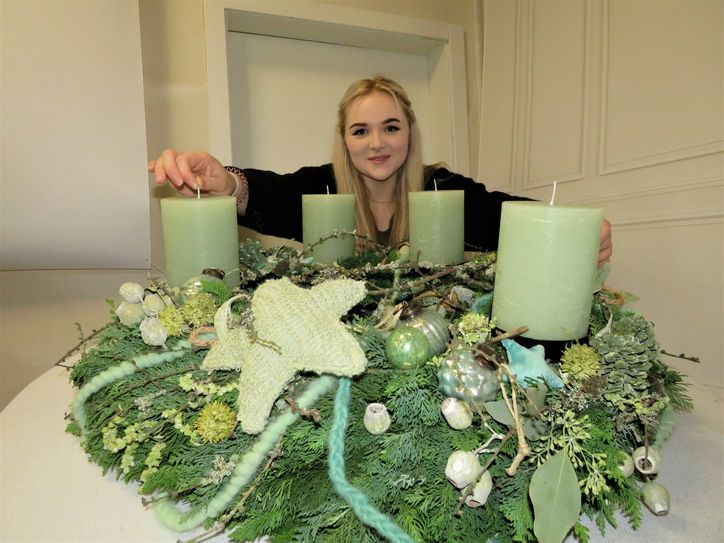 Hanna Bock und ihr Kunstwerk. Der Adventskranz ist ein Unikat und präsentiert das talentierte Handwerksgeschick der 18-jährigen angehenden Floristin. Foto: Silke Richter
