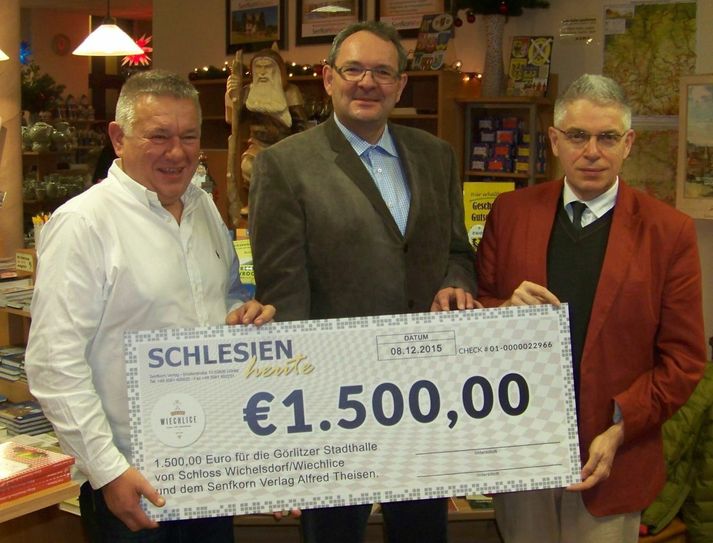 Zbigniew Czmuda (l.) und Alfred Theisen (r.) bei der symbolischen Scheckübergabe an den Vorsitzenden des Stadthallenvereins Thomas Leder in der Schlesischen Schatztruhe am Dienstag, den 8. Dezember 2015. Foto: PR