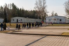 Gruppe auf dem Weg zur Ausstellungsbaracke (links) auf dem Gelände der Landesfeuerwehrschule