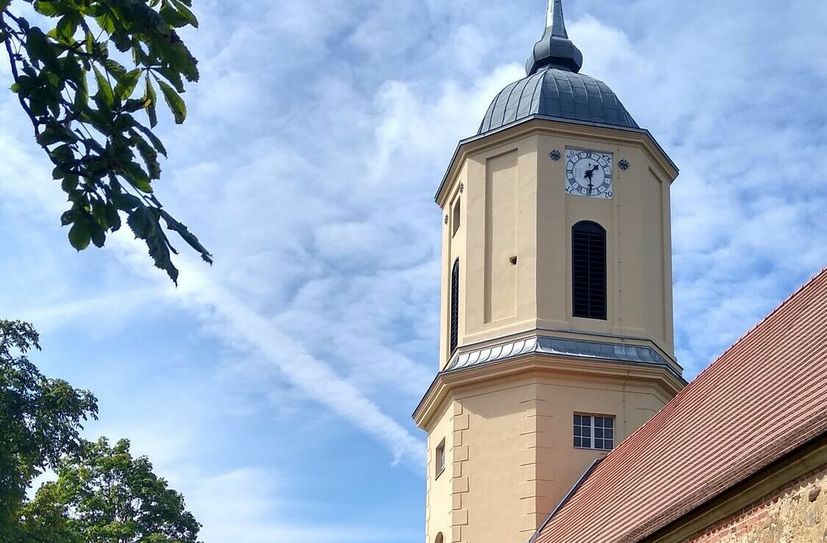 Der Kirchturm in Zützen ist saniert. Die vergoldete Turmzier leuchtet schon von weitem in der Sonne.