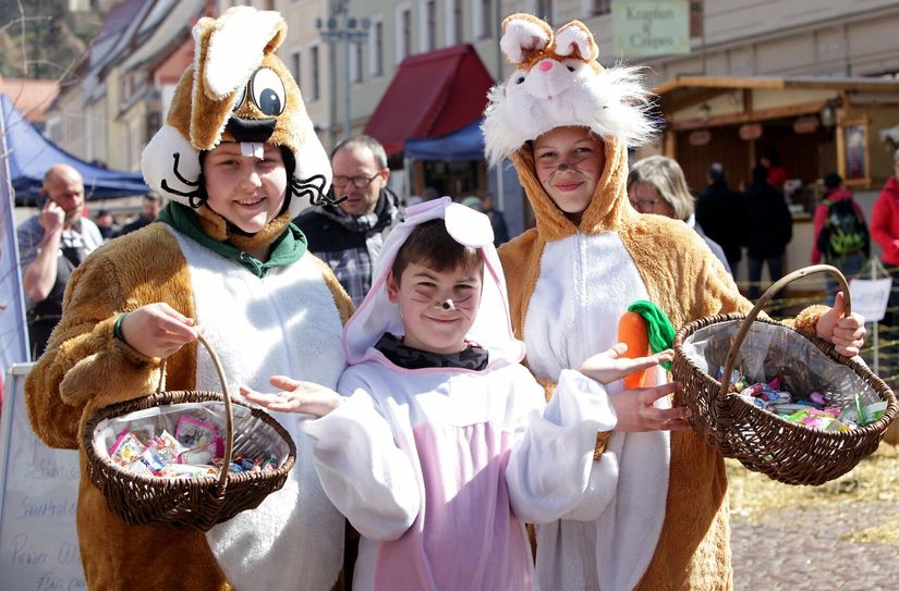 In Hasenkostüme gekleidete Jugendliche überraschen die Besucher mit Naschereien.