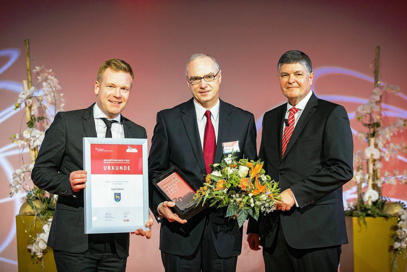 Lars Waetzold vom Ostsächsischen Sparkassenverband (li.) und Wolfgang Zender (re.) überreichten Mike Ruckh den Preis. Foto: PR