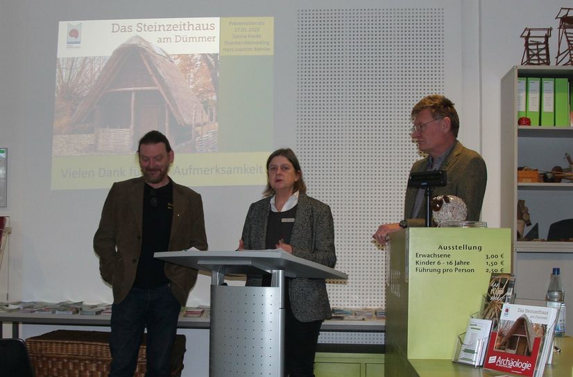 Thorsten Helmerking, Sabine Hacke und Dr. Hans Joachim Behnke (v.l.n.r.) präsentieren das Buch vom Steinzeit-Hausbau im ATZ Welzow.