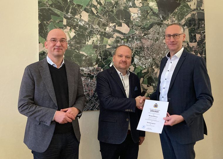 Dr. Robert Böhmer (l.), und Oberbürgermeister Karsten Vogt (r.) überreichen dem neuen Ordnungsamtsleiter Michael Böhmer die Ernennungsurkunde.