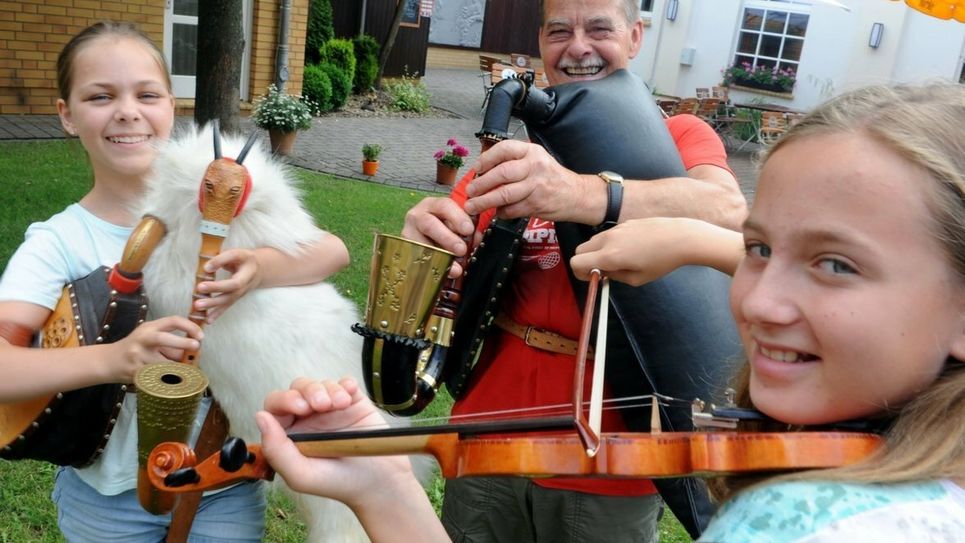 Der Leiter des Folkloreensembles Schleife, Wolfgang Kotissek, am Dudelsack – hier mit zwei sorbischen Nachwuchsmusikerinnen. Foto: Rehle