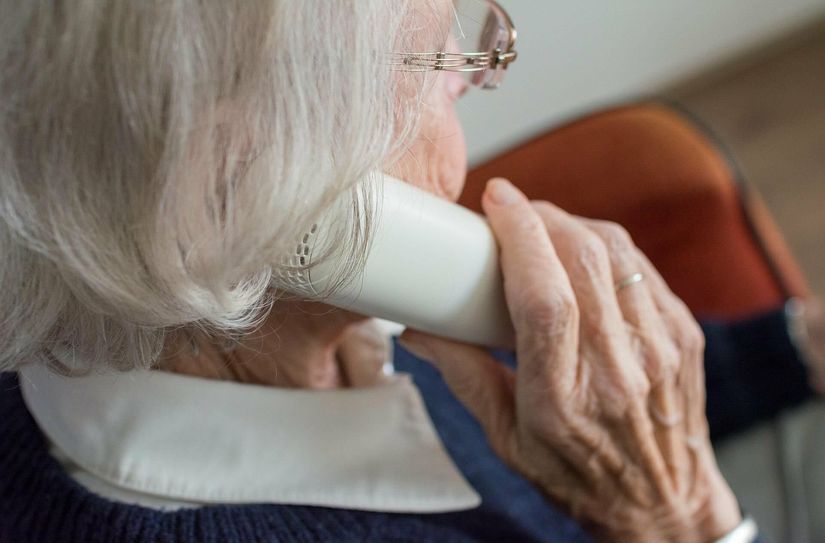 Die ältere Dame holt sich über das Seniorentelefon Unterstützung.