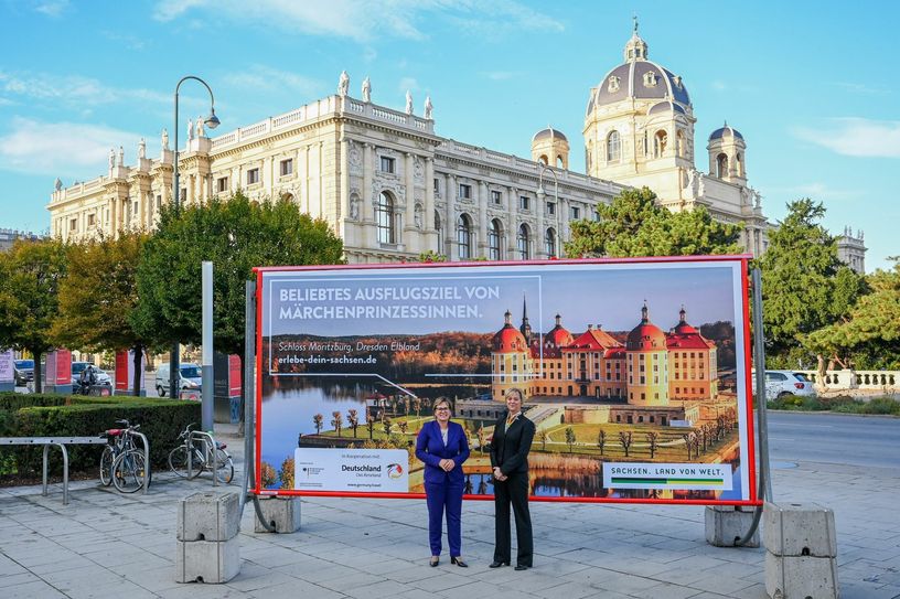 V.l.: Sachsens Tourismusministerin Barbara Klepsch und Veronika Hiebl, Geschäftsführerin der Tourismus Marketing Gesellschaft Sachsen mbH (TMGS), enthüllten das Plakat am Wiener Museumsplatz. Im Hintergrund ist das Kunsthistorische Museum zu sehen. Foto: SMKT