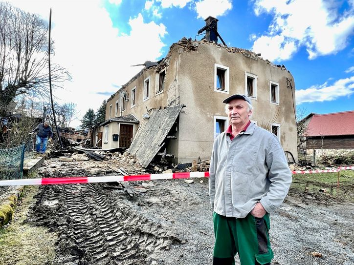 Manfred L. steht vor seinem Haus und dahinter die ehemalige Scheune – alles ist verbrannt. Untergekommen sind er und seine Mutter bei einem Freund im Ort.