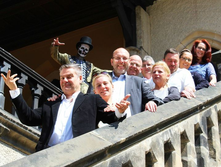 Die Festspielgemeinschaft gemeinsam mit den Schauspielern Tom Quaas (l.) und Holger Uwe Thews als Tod (im Hintergrund): Theatergeschäftsführerin Ann-Kristin Böhme, OB Olaf Raschke, Landesbühnenintendant Manuel Schöbel, Domkantor Jörg Bräunig, Renate Fiedler - Freundeskreises Theater Meißen, Lutz Krüger - Winzergenossenschaft Meißen, Katja Richter - Albrechtsburg Meißen,  Jane Taubert -  Landesbühne (v.l.). Foto: Stadt