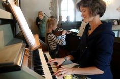 Musiklehrerin Adéla Drechsel aus Pirna-Liebethal musiziert mit Kindern und jungen Leuten an der Orgel auf der Empore.