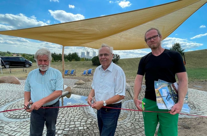 Johannes Miethe von Miethe-Bau (links), Findlingspark-Geschäftsführer Klaus Tschöke (Mitte) und Matthias Ebeling von der Planungswerkstatt von Plantura durchschneiden das Band bei der Einweihung des neuen Wasserspielplatzes.