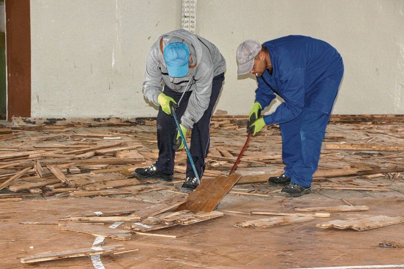 Mit echter Muskelkraft geht es dem alten Parkett in der Turnhale an den Kragen. Das Gebäude wird abgerissen und das alte Holz entsorgt. Foto: Farrar