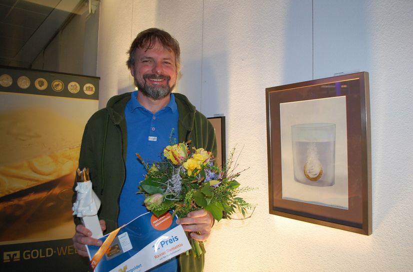 Gewinner Rainer Demattio neben seiner ausgezeichneten Karikatur »Bei Kopfschmerzen«.
