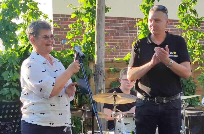 Jens Muschter übergibt die Spende der Edeka Kunden im Brauhausgarten an Elvira Mader.