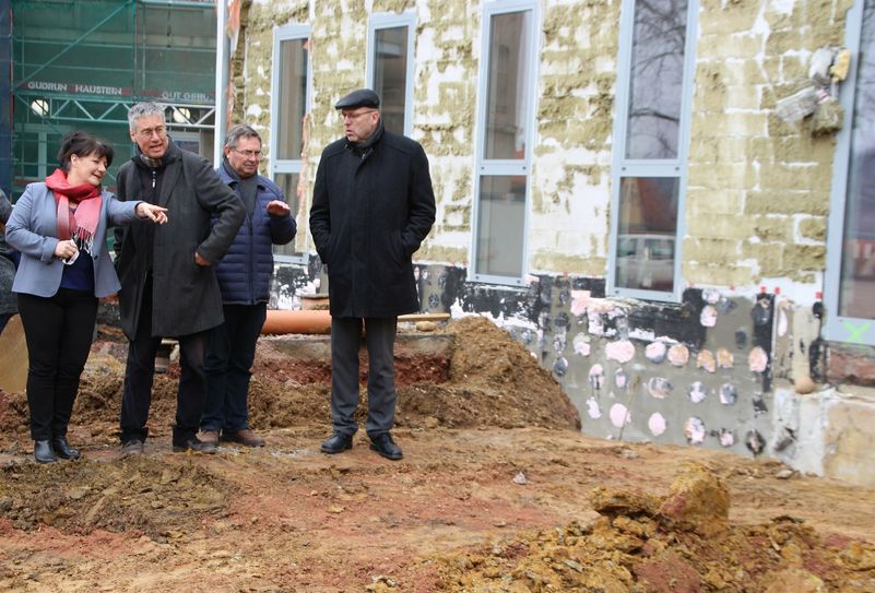 Schulleiterin Heike Zimmer lässt sich von Planer Dr. Knut Hauswald erklären, wie die Anbindung des neuen Gebäudes an den bestehenden Schulbau geplant ist. Michael Werner vom Stadtbauamt und Oberbürgermeister Olaf Raschke (v.l.) sehen sich die Baugrube und den felsigen Untergrund an.