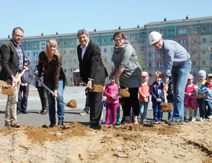 Neugierig schauen die Kinder der Regenbogenvilla zu, wie Uwe Glotz (Geschäftführer Neu & Reko Bau Glotz), Andrea Mögel (Erzieherin Kinderhaus Sonnenschein), OB Holm Große, Madlen Wild (Leiterin Regenbogenvilla) und Michael Matthes (Bauleiter Bauplanung Bautzen/ v.l.n.r.) den ersten Spatenstich für das neue Kinderzentrum Südstadt in Bischofswerda vollzogen. Fotos: Stadtverwaltung