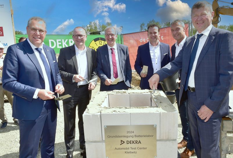 Rainer Genilke (Minister für Infrastruktur in Brandenburg), Guido Kutschera (Vorsitzender der Geschäftsführung DEKRA Automobil GmbH), Hendrik Fischer (Staatssekretär im Wirtschaftsministerium Brandenburg), Erik Pellmann (Leiter DEKRA Technologie Center Klettwitz), Klaus Prietzel (Bürgermeister Schipkau) und Siegurd Heinze (Landrat OSL) mauern die Zeitkapsel zur Grundsteinlegung ein.  Foto: Peter Aswendt